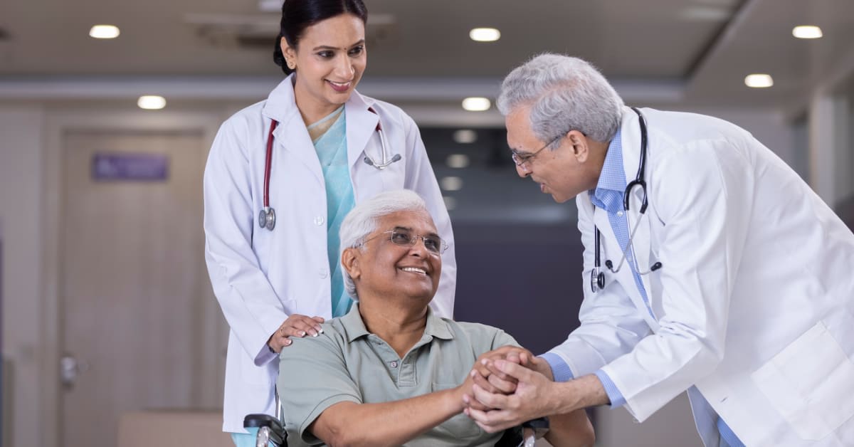 Doctors speaking with a patient in a medical setting, reflecting medical travel issues addressed by immigration attorneys.