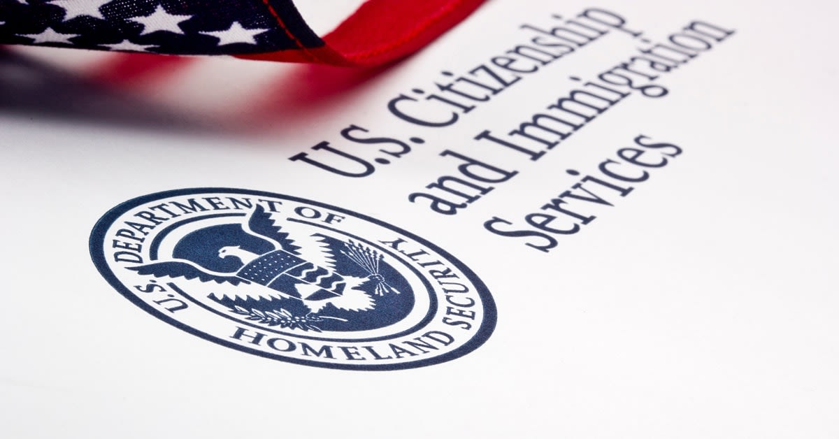 U.S. Citizenship and Immigration Services document with an American flag, representing immigration policy matters handled by immigration attorneys.