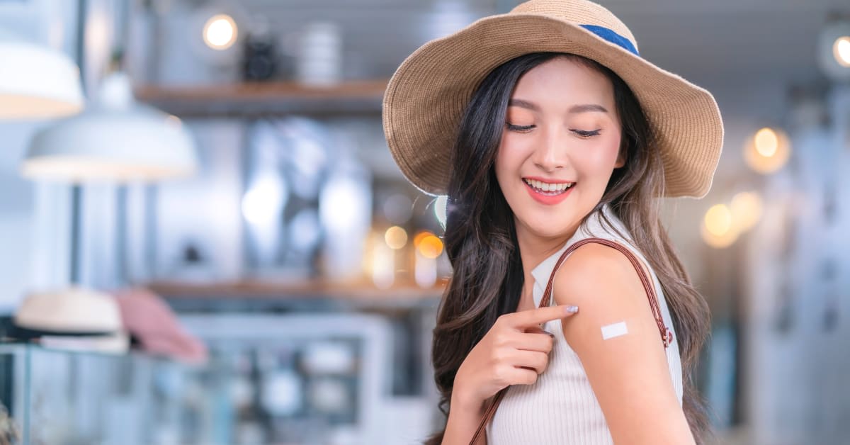 A person pointing to a bandage on their arm, reflecting vaccination documentation matters assisted by immigration attorneys.