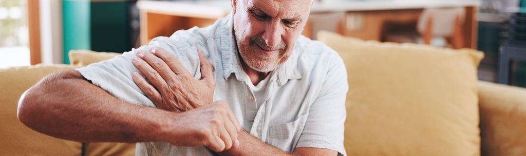 Older man experiencing shoulder pain associated with a vaccine-related shoulder injury