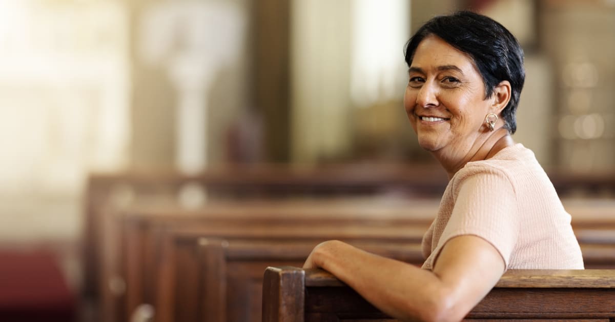 Woman sitting in a place of worship, representing sincerely held religious beliefs for vaccine exemption