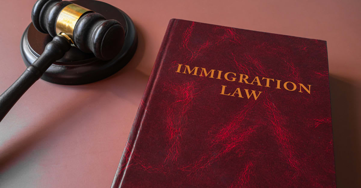 Red immigration law book beside a judge’s gavel, representing legal matters handled by immigration attorneys.